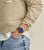 Pulsera de hombre en la muñeca con esfera azul y correa de acero inoxidable.