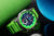 Reloj de hombre con correa verde y esfera verde, detalles de cronógrafo