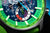 Primer plano: esfera de reloj para hombre con bisel verde, "Hecho en Lituania"