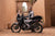 Reloj de hombre en la muñeca, junto a una motocicleta en un viaje