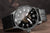Pulsera de hombre con esfera negra, correa de cuero beige y distintivos números arábigos