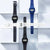 Cuatro relojes digitales con pulseras de plástico, pantallas LCD rectangulares en azul y negro