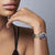 Reloj de mujer en la muñeca con esfera azul y pulsera de metal dorado y plateado