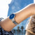Reloj de mujer en la muñeca con esfera azul y pulsera plateada