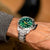 Reloj de buceo en la muñeca con esfera verde y correa de acero inoxidable