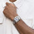Pulsera de acero inoxidable para hombre en la muñeca, brazalete plateado con eslabones entrelazados.