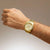 Reloj de hombre en la muñeca, pulsera de acero inoxidable dorada y esfera plateada y amarilla