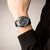 Reloj cronógrafo para hombre en la muñeca con correa de camuflaje negra y cronógrafo