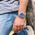 Reloj de hombre en la muñeca con esfera azul y correa de acero inoxidable
