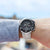 Reloj deportivo para hombre en la muñeca con esfera negra y correa de metal