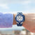 Reloj de hombre en la muñeca con esfera azul, cronógrafo y correa