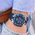 Reloj de hombre en la muñeca con esfera azul y correa de caucho azul oscuro