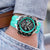 Reloj de hombre en la muñeca: pulsera de silicona turquesa, esfera negra de cronógrafo