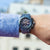 Reloj de hombre en la muñeca con correa azul y pantalla de cronógrafo