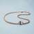 Pulsera con charm en tono oro rosa e inserto trenzado azul