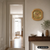 Wanduhr aus hellem Eichenholz mit Glasfront und rundem Zifferblatt an der Wand