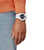 Pulsera de hombre en la muñeca con correa blanca y pantalla digital negra