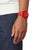 Reloj de hombre rojo en la muñeca con caja de plástico y correa de silicona