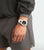 Pulsera de hombre en la muñeca con correa blanca y esfera negra