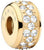 Charm de acero inoxidable en tono dorado con agujero redondo y piedras en el borde
