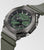 Reloj de hombre en diagonal frontal: esfera verde, bisel robusto, correa de silicona verde, pantalla.