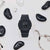 Reloj G-Shock para mujer en color negro sobre fondo claro, con esfera redonda y correa de resina.