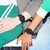 Reloj deportivo digital negro en dos muñecas con correa de caucho.