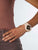 Reloj de mujer en la muñeca con correa beige y esfera negra
