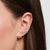 Pendientes Infinity con circonita cúbica redonda, tono oro amarillo, llevados en la oreja