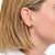 Pendientes dorados de Thomas Sabo con forma de gota curvada y brillante en la oreja