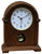 Reloj de mesa de madera con esfera redonda y orificio de cuerda; caja marrón, base.