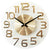 Reloj de pared redondo de cristal con números dorados, dos manecillas y marca central JVD