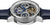 Reloj de hombre con esfera esqueletizada y manecillas azules, engranajes visibles