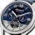Reloj de hombre con esfera azul, números romanos y movimiento automático visible