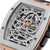 Primer plano: reloj automático para hombre con esfera abierta, bisel en tono oro rosa, correa negra.