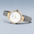 Reloj redondo de mujer con bisel dorado, esfera blanca y correa de malla gris