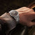 Reloj Seiko para hombre en la muñeca con esfera negra y correa de acero inoxidable