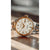 "Reloj de mujer con esfera color crema, bisel dorado y brazalete metálico bicolor"