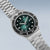 Pulsera de hombre vista lateral con esfera verde, brazalete de acero inoxidable plateado