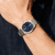 Pulsera de hombre en la muñeca: esfera azul, brazalete de metal plateado.