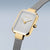 "Reloj de mujer con esfera rectangular plateada y bisel dorado, correa milanesa"