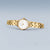Reloj de mujer estilo vista frontal con esfera blanca y pulsera de eslabones dorados.