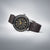 Reloj Seiko para hombre de lado: correa de cuero marrón, bisel negro, esfera oscura con marcadores dorados
