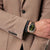 Reloj de hombre en la muñeca con esfera verde y pulsera metálica bicolor