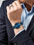 Pulsera en la muñeca con esfera azul y correa milanesa