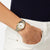 Reloj de hombre en la muñeca con pulsera plateada y bisel dorado