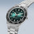 Pulsera de hombre, vista frontal, con esfera verde Sunray, bisel negro y brazalete de metal