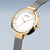 "Reloj de mujer con caja dorada, esfera blanca y brazalete de metal gris"