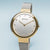 "Reloj de mujer con pulsera milanesa plateada, bisel dorado, esfera blanca"