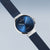 Reloj de mujer en vista lateral: esfera azul, bisel de acero inoxidable y correa milanesa azul oscuro